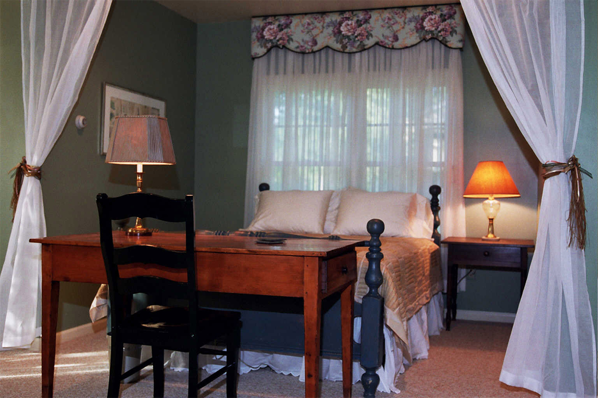 Sleeping area of The Red Cottage with desk